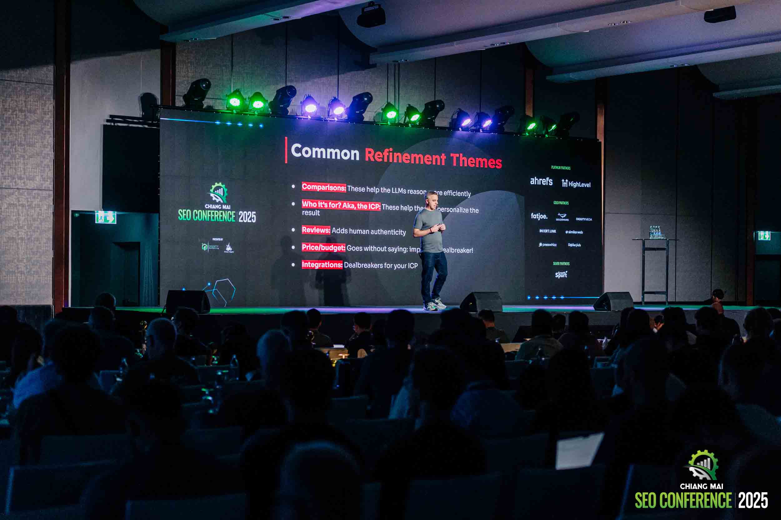Un presentatore parla sul palco di fronte a un vasto pubblico alla Chiang Mai SEO Conference durante una sessione incentrata sulla SEO
