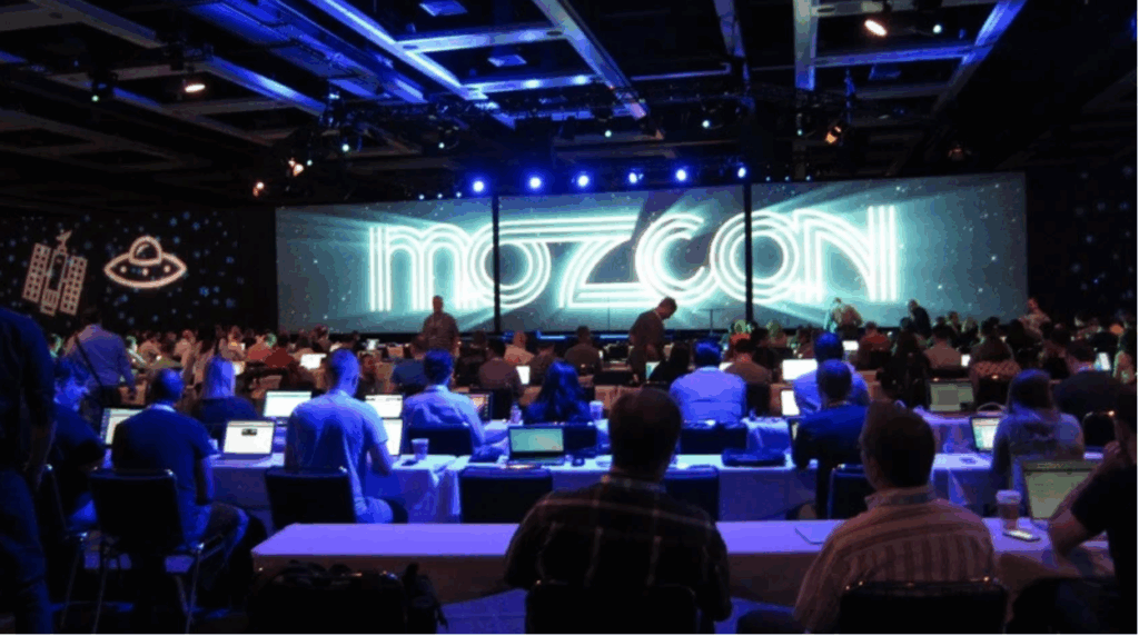 A photo of attendees watching a presentation at the MozCon conference.