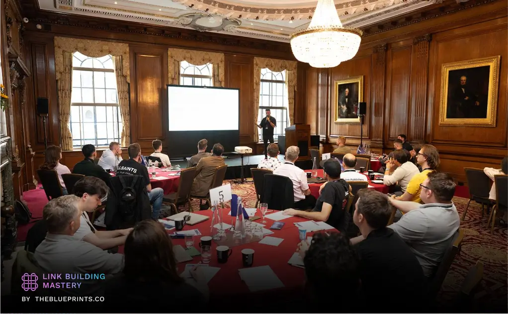 A speaker presenting to a full audience at the Link Building Mastery Conference