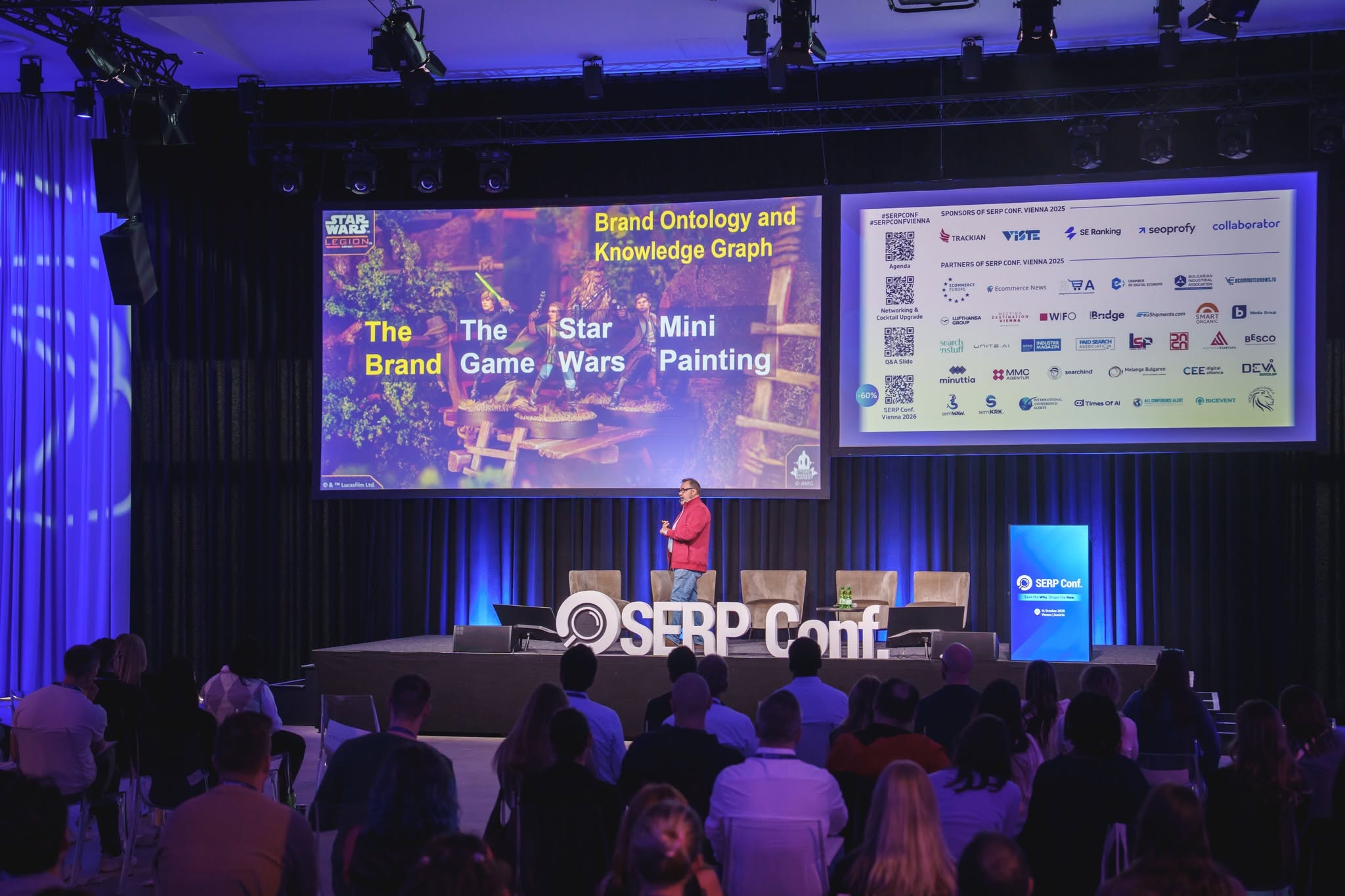 Un relatore parla sul palco al SERP Conf mentre i partecipanti assistono a una sessione keynote su strategie di search marketing e SEO
