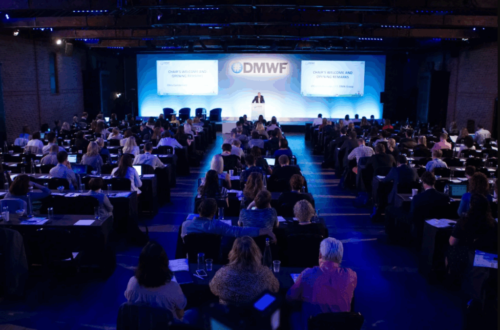 An image of a speaker presenting on stage and the attendees seated at the Digital Marketing World Forum