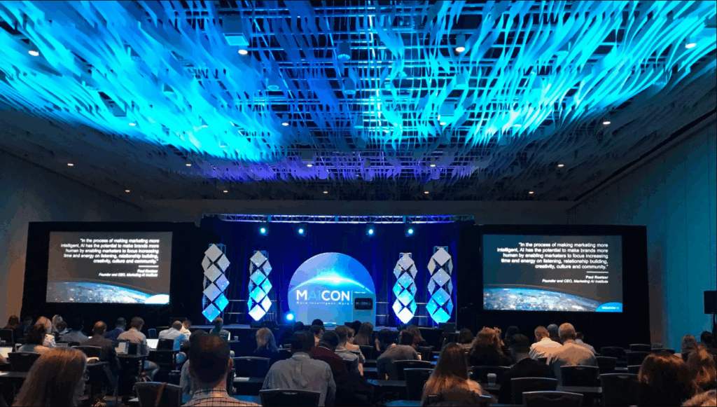 An image of the attendees seated and the MAICON conference setup