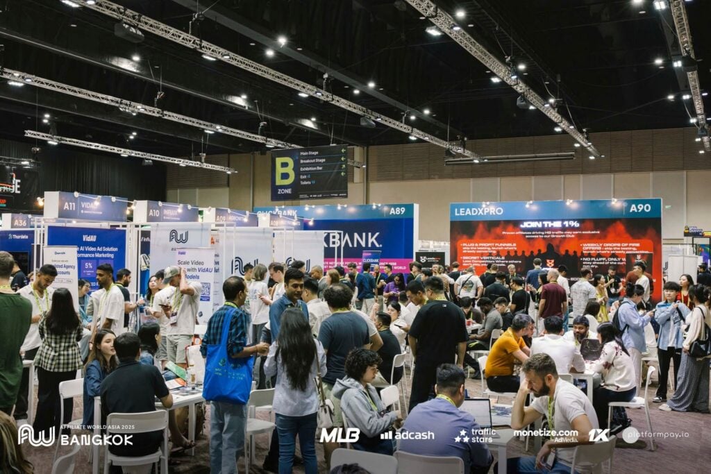 A crowded exhibition hall with attendees interacting at booths during Affiliate World