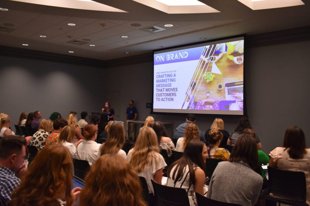 Conference audience during a speaker presentation at the On Brand Conference.