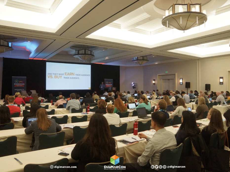 A photo of a DigiMarCon conference session with attendees watching a presentation.